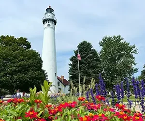 Wind Point lighthouse on a pleasant day with colorful flowers in the foreground